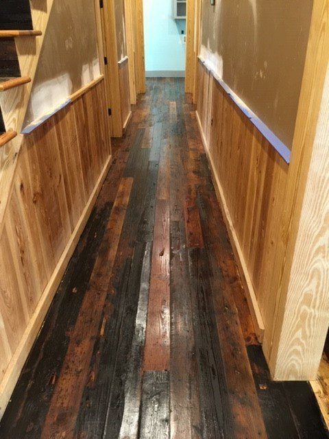 a long hallway with a wooden floor and stairs