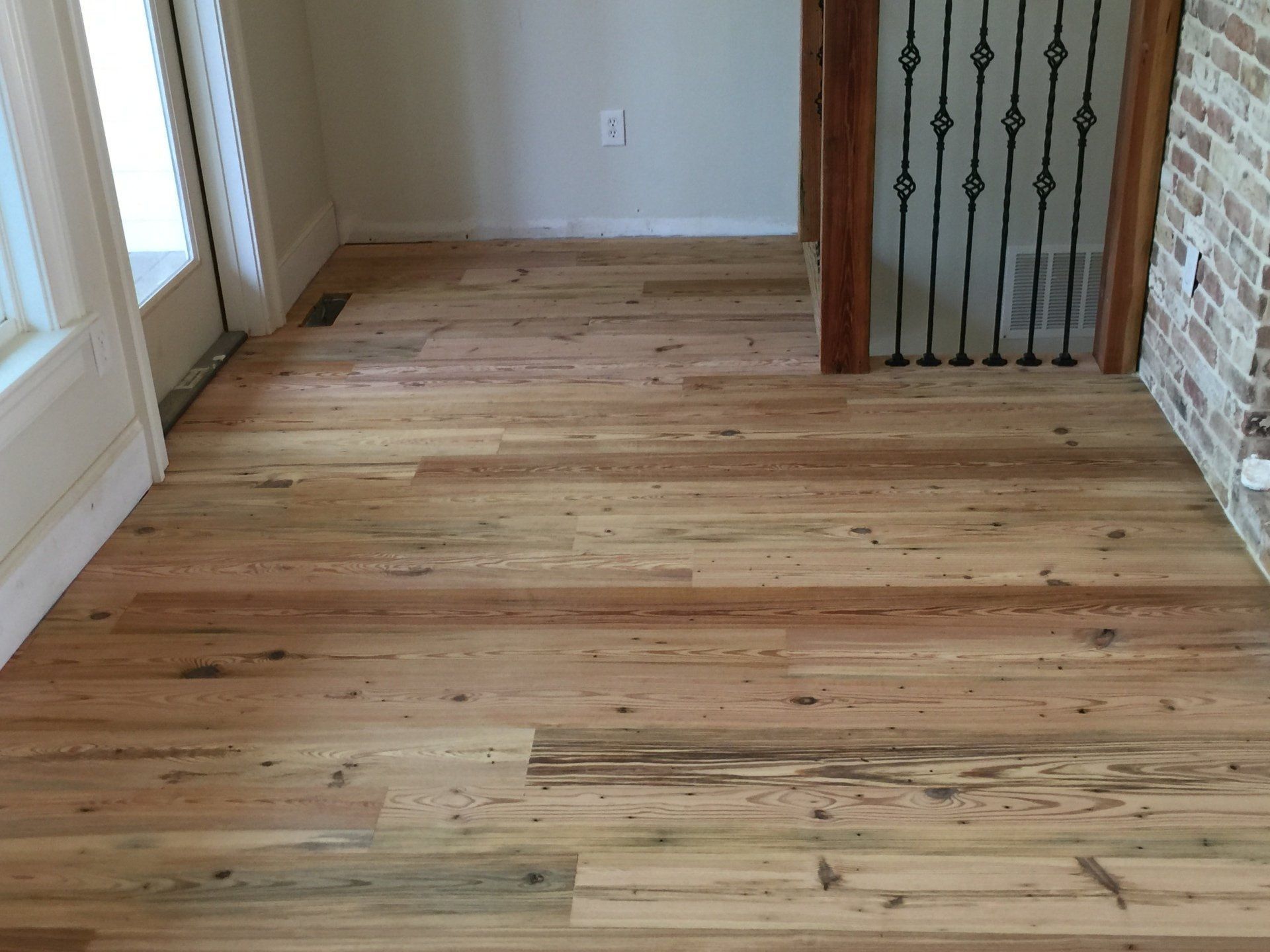 a room with a wooden floor and a brick wall