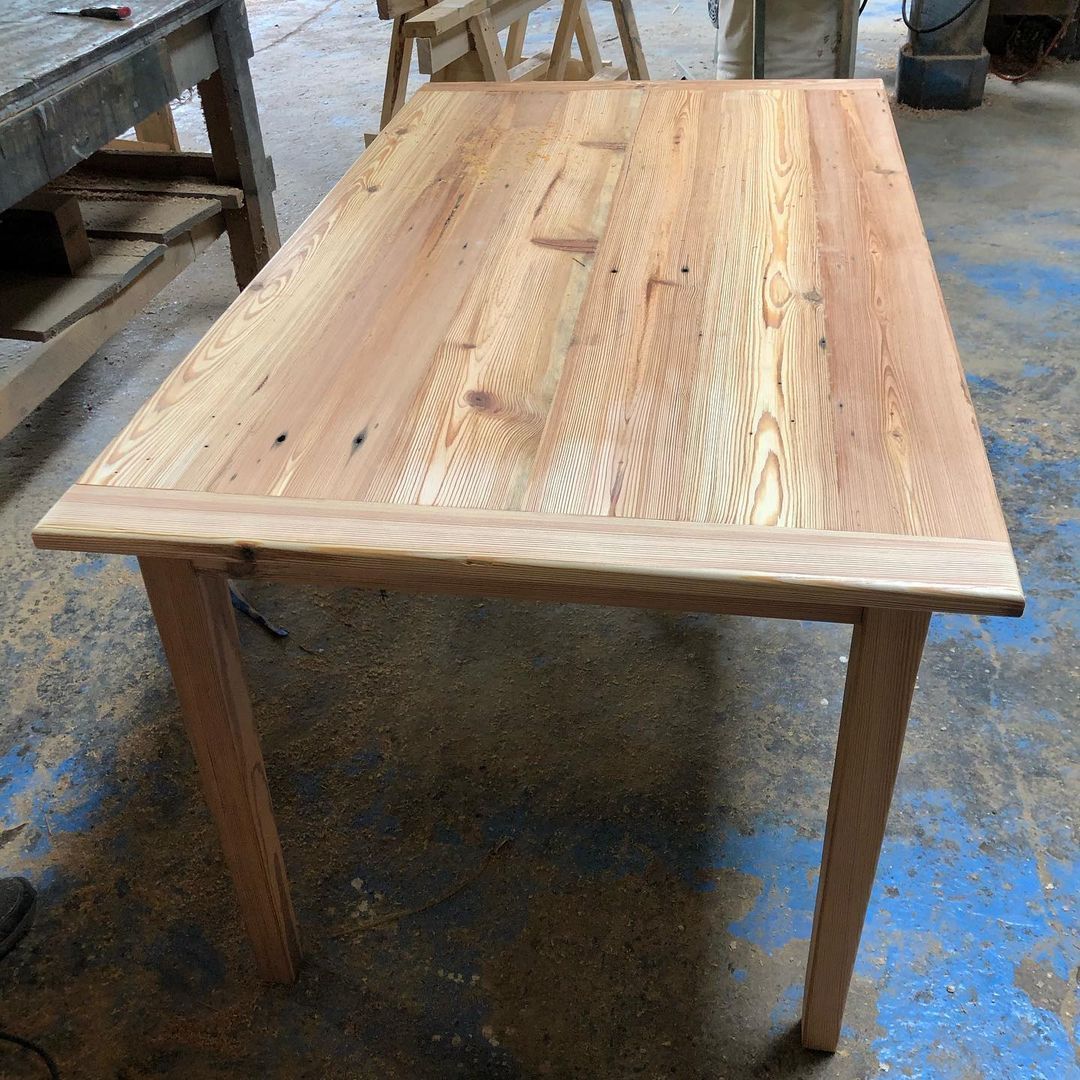 a wooden table is sitting on the floor in a workshop