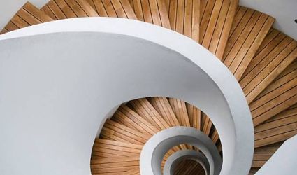 A spiral staircase with wooden steps and a white railing.