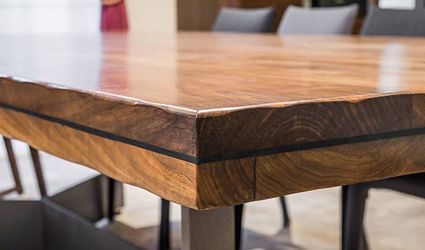 A close up of a wooden table with a black stripe on the edge.