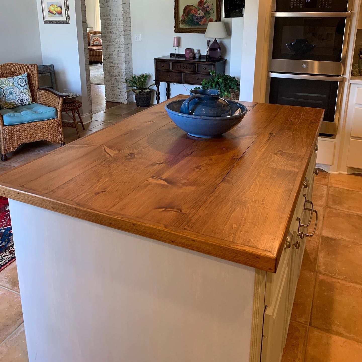 A wooden bar with a bowl on top of it in a kitchen.
