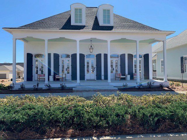 a white house with black shutters and a porch