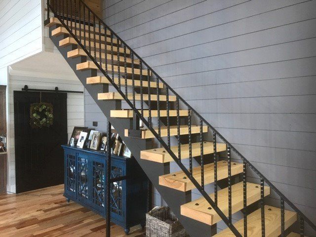 a wooden staircase with a metal railing in a living room