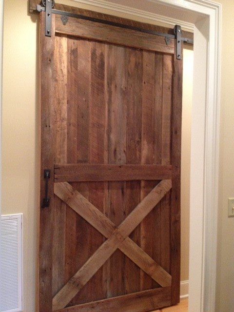 a wooden sliding barn door with a cross on it