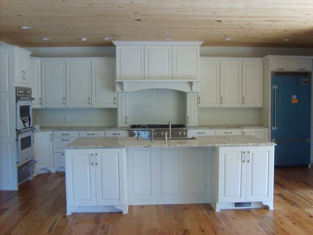 a kitchen with white cabinets and a large island