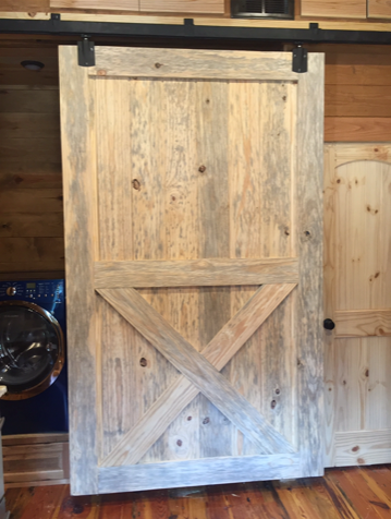 a wooden sliding barn door is sitting in a room next to a washer and dryer
