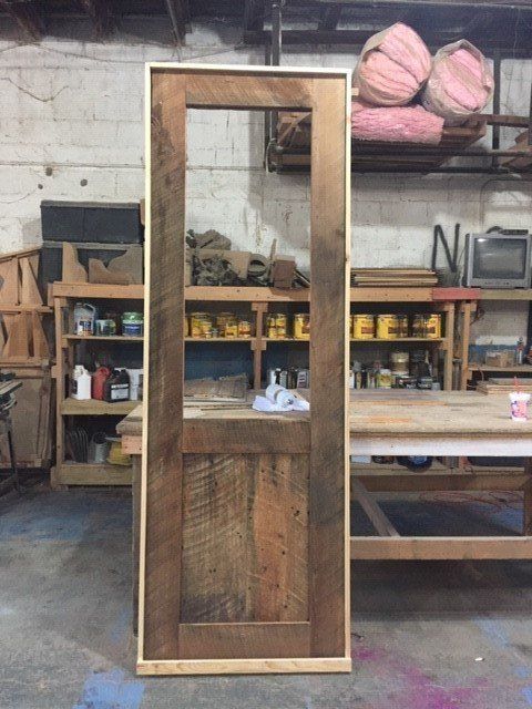 a wooden door is sitting on a table in a workshop