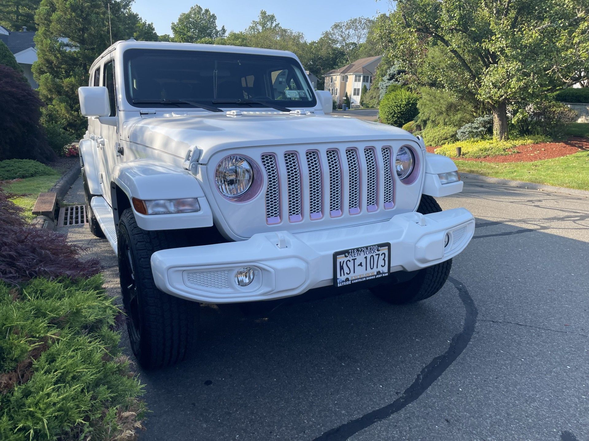 A white jeep is parked on the side of the road.