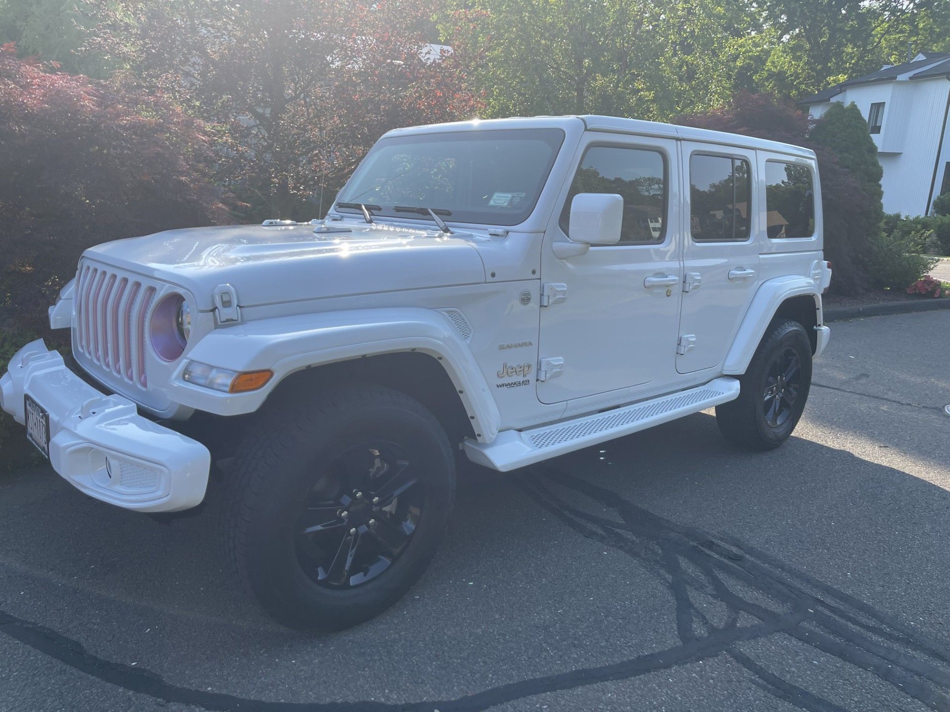 A white jeep wrangler is parked on the side of the road.