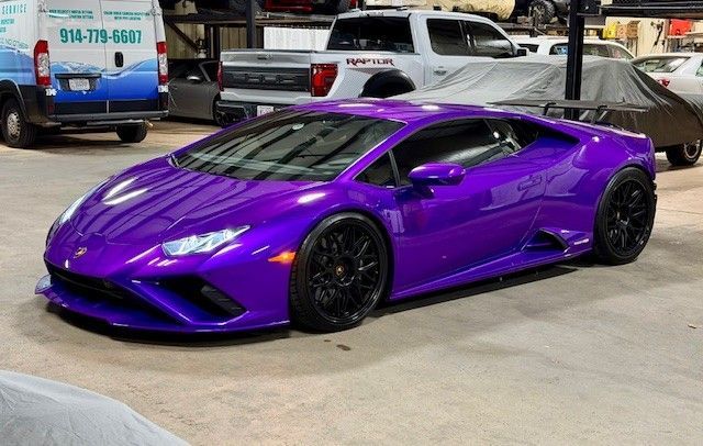 Purple Lamborghini sports car parked in a garage.