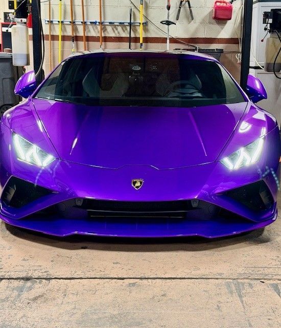 Purple Lamborghini Huracan sports car in a garage.