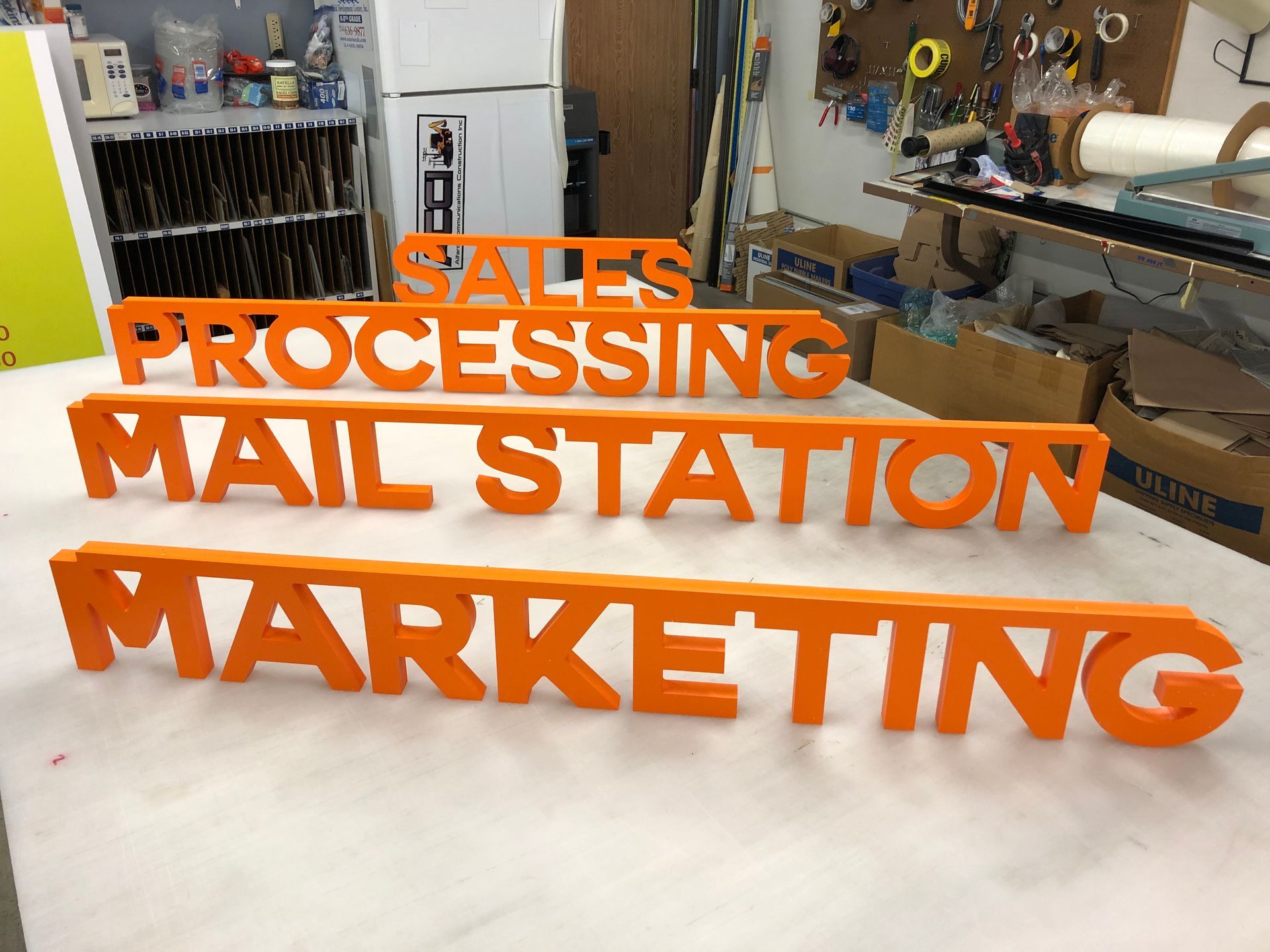 Orange letters that say sales processing mail station marketing