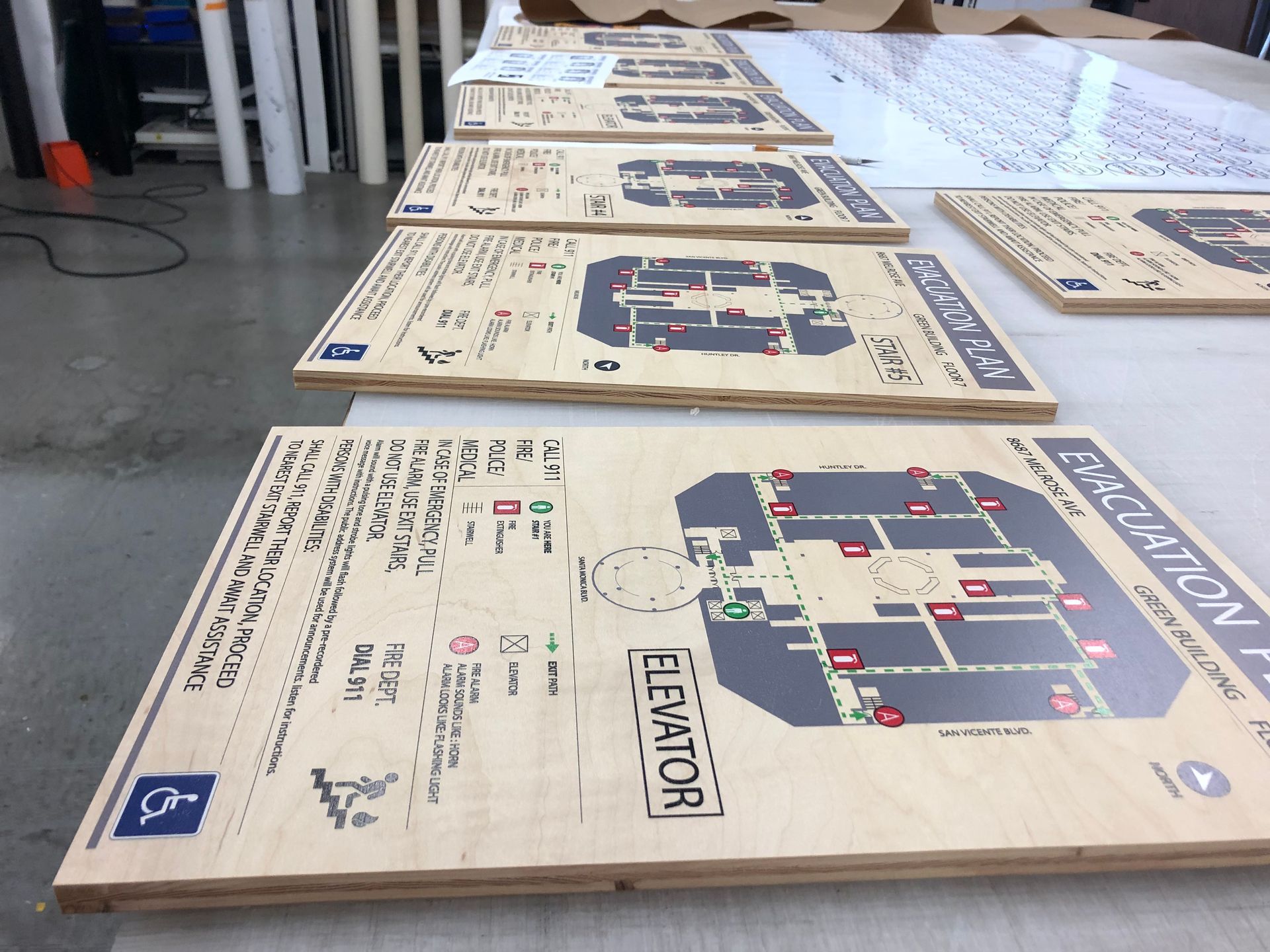 A row of wooden elevator maps on a table