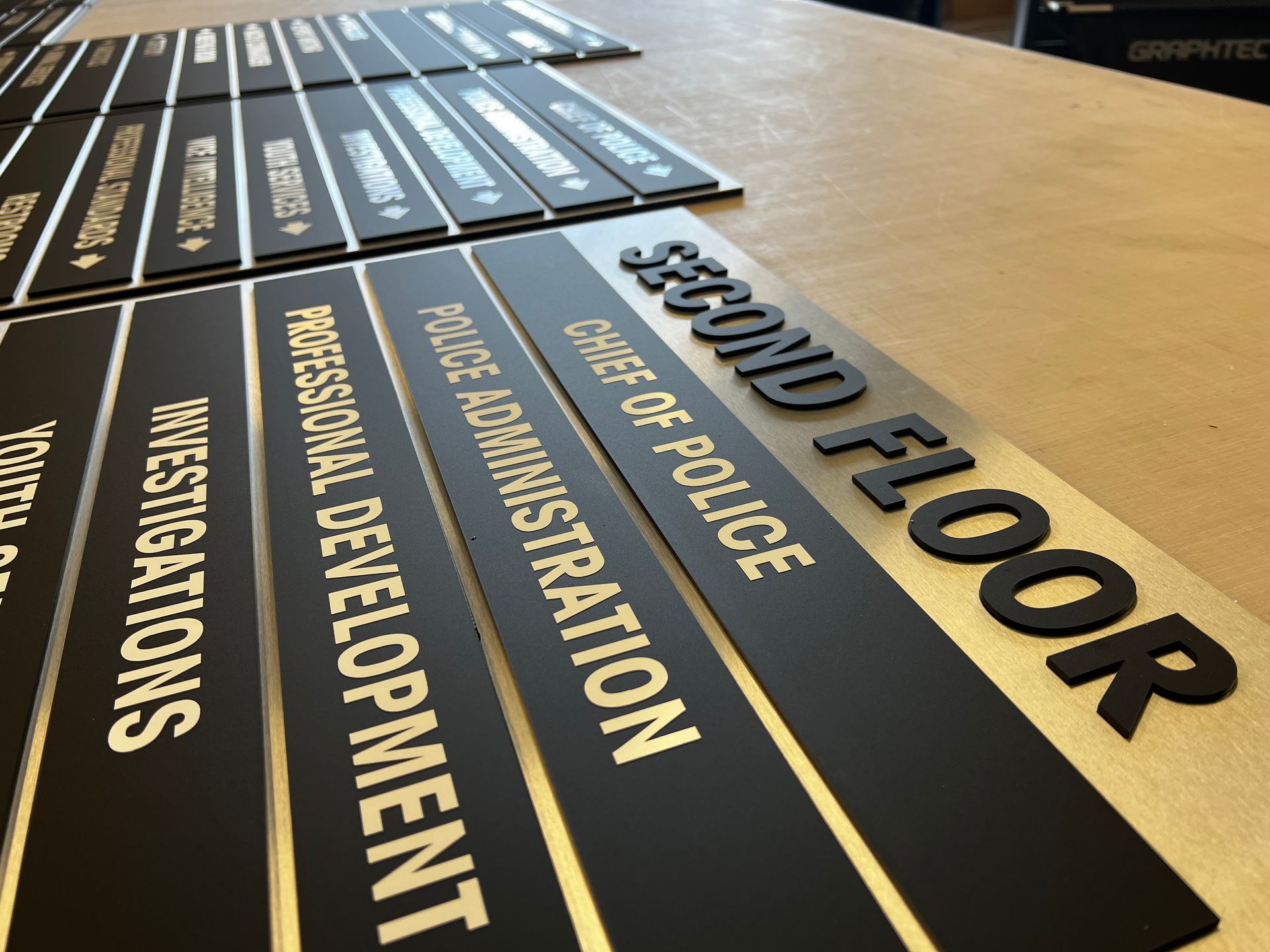 A row of black and gold signs that say second floor