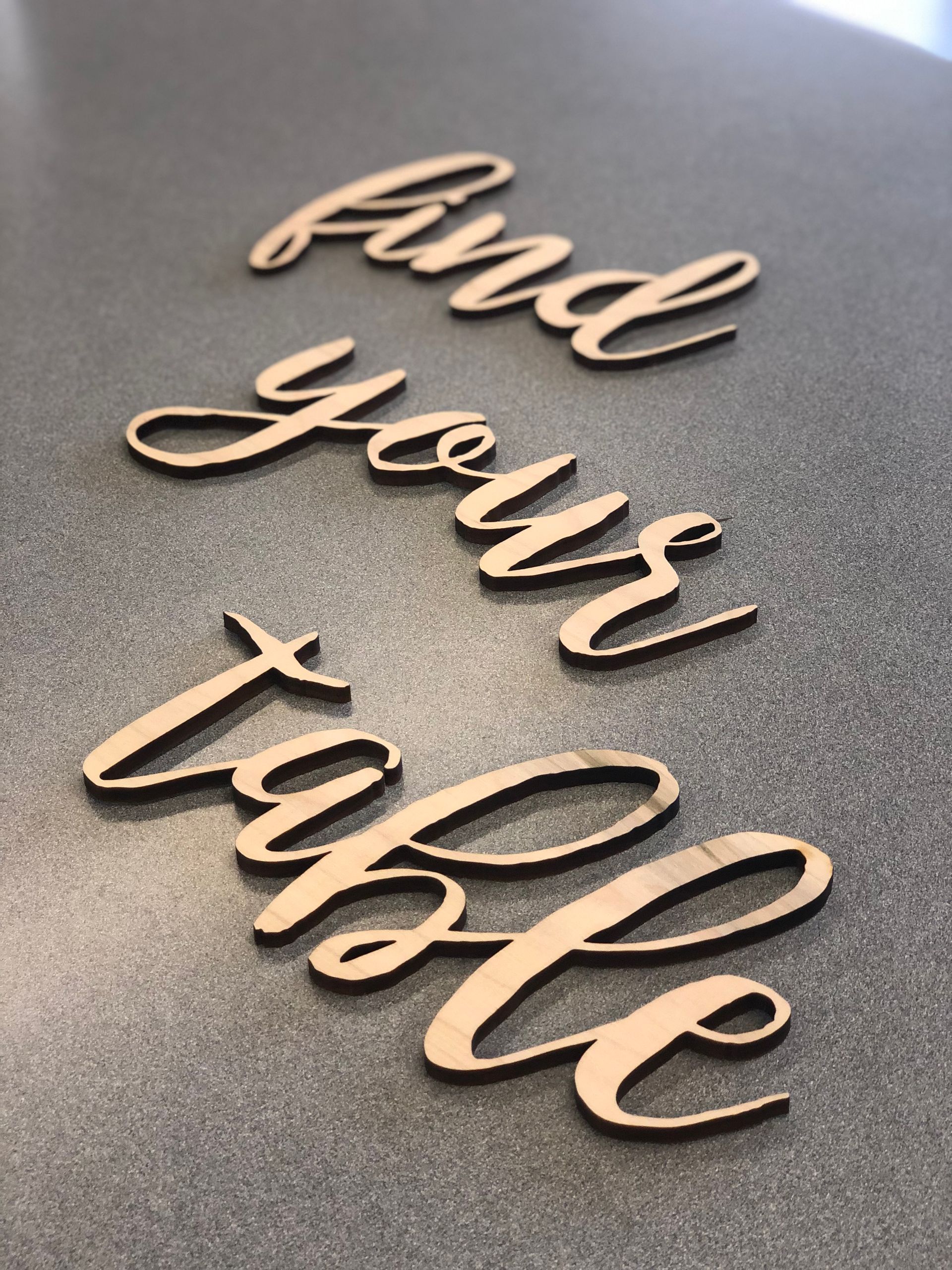 A wooden sign that says find your table