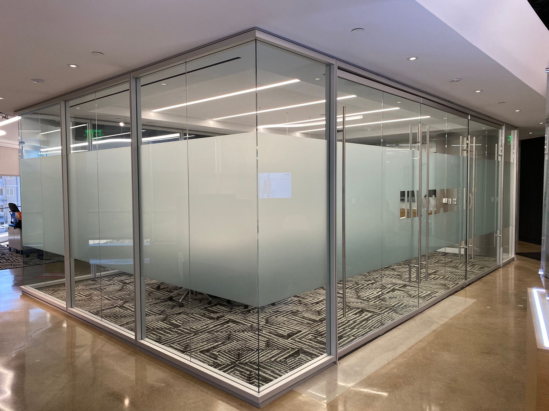 A room with a lot of glass walls and a carpeted floor.