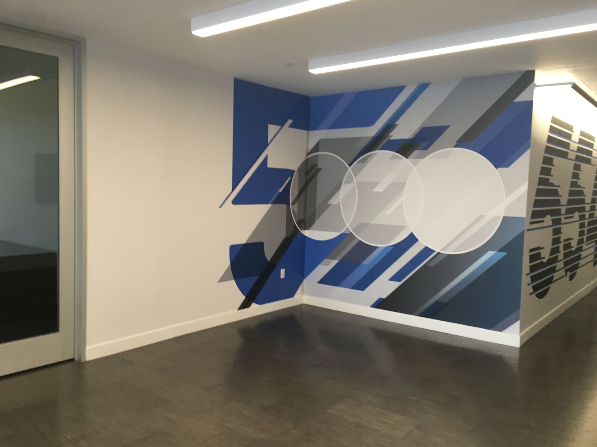 A corner of a room with a mural on the wall