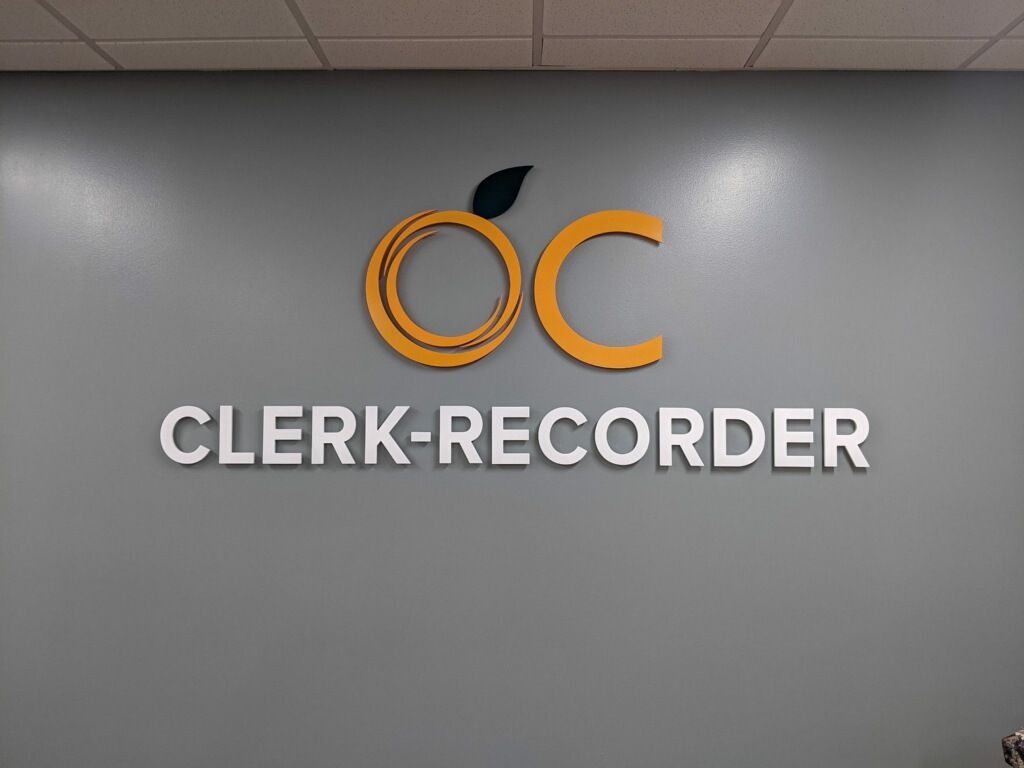 A sign on a wall that says clerk-recorder