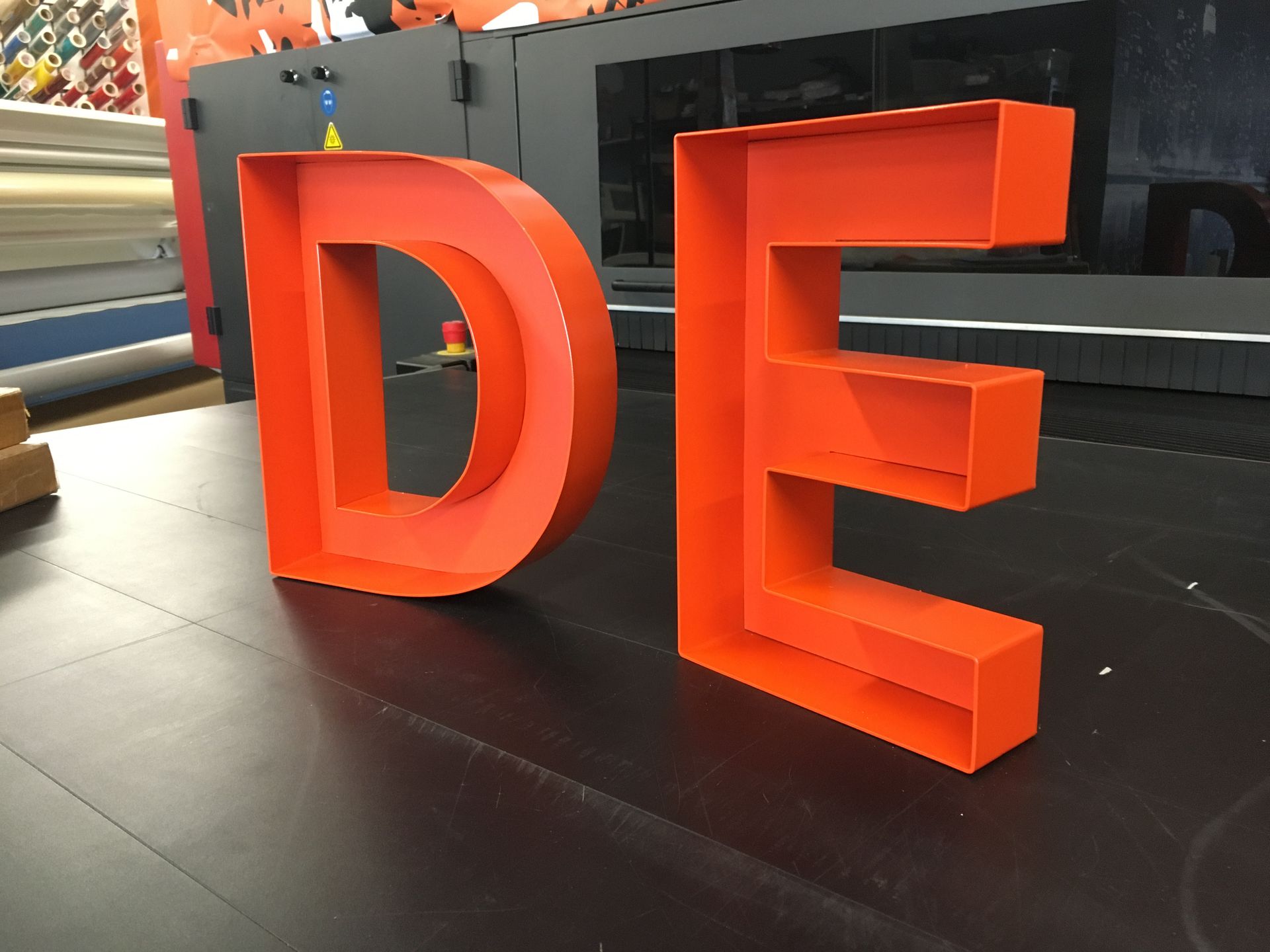 A large orange letter de is sitting on a table