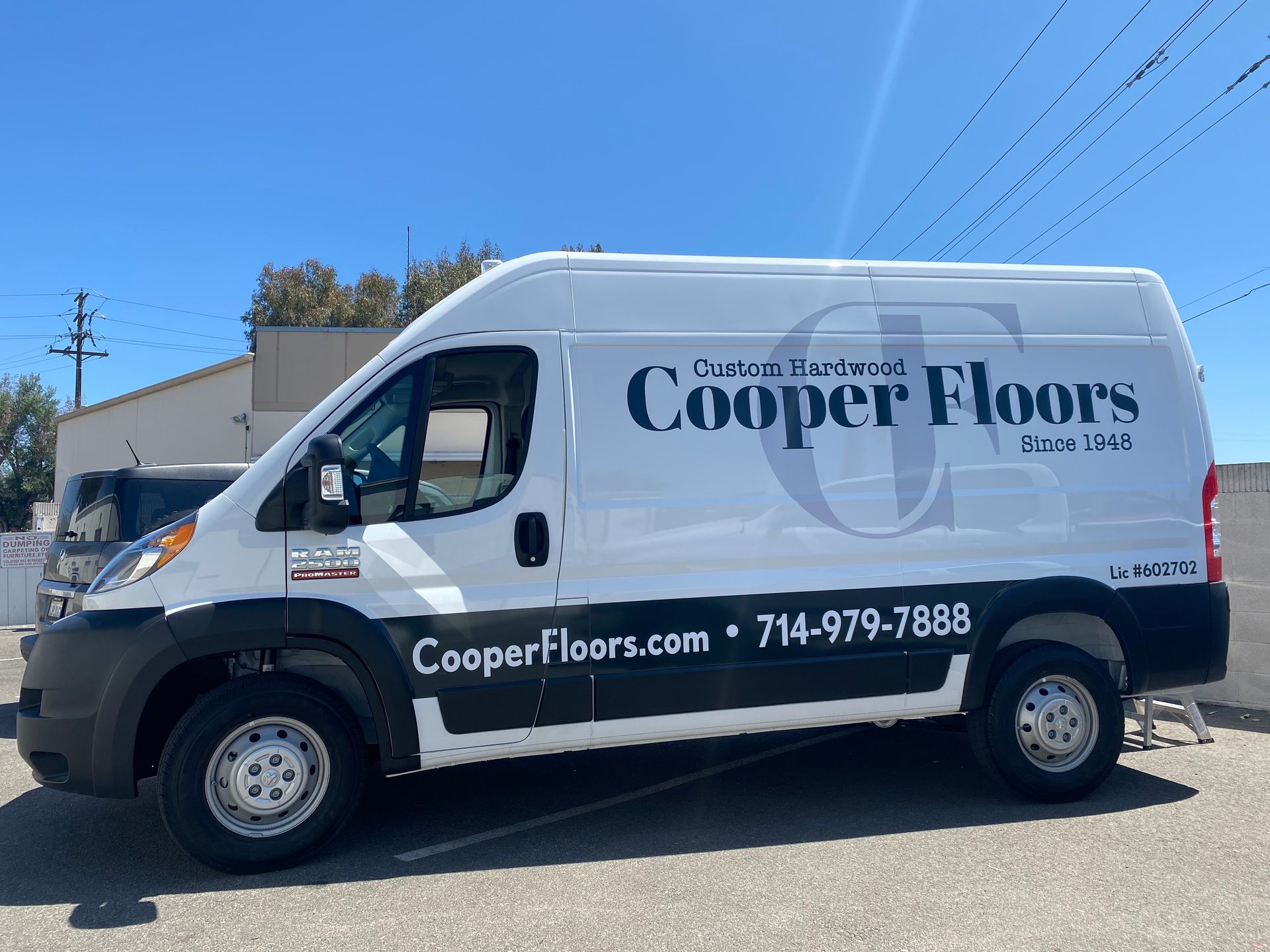 A cooper floors van is parked in a parking lot