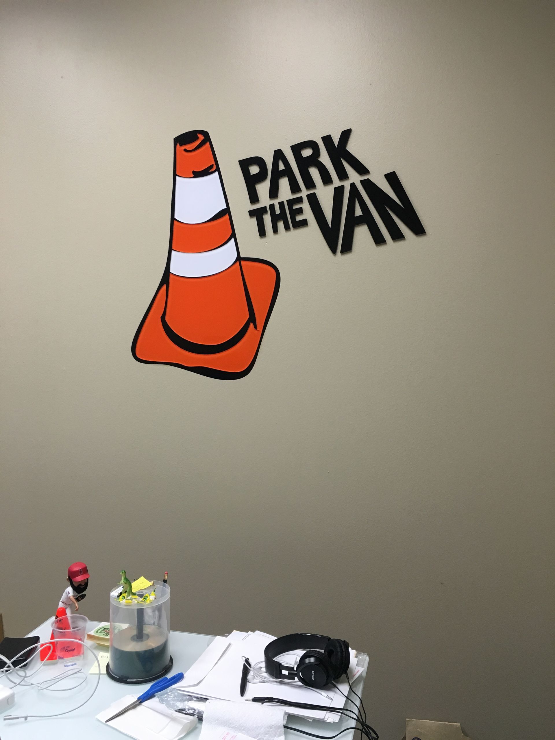 A sign on a wall that says park the van