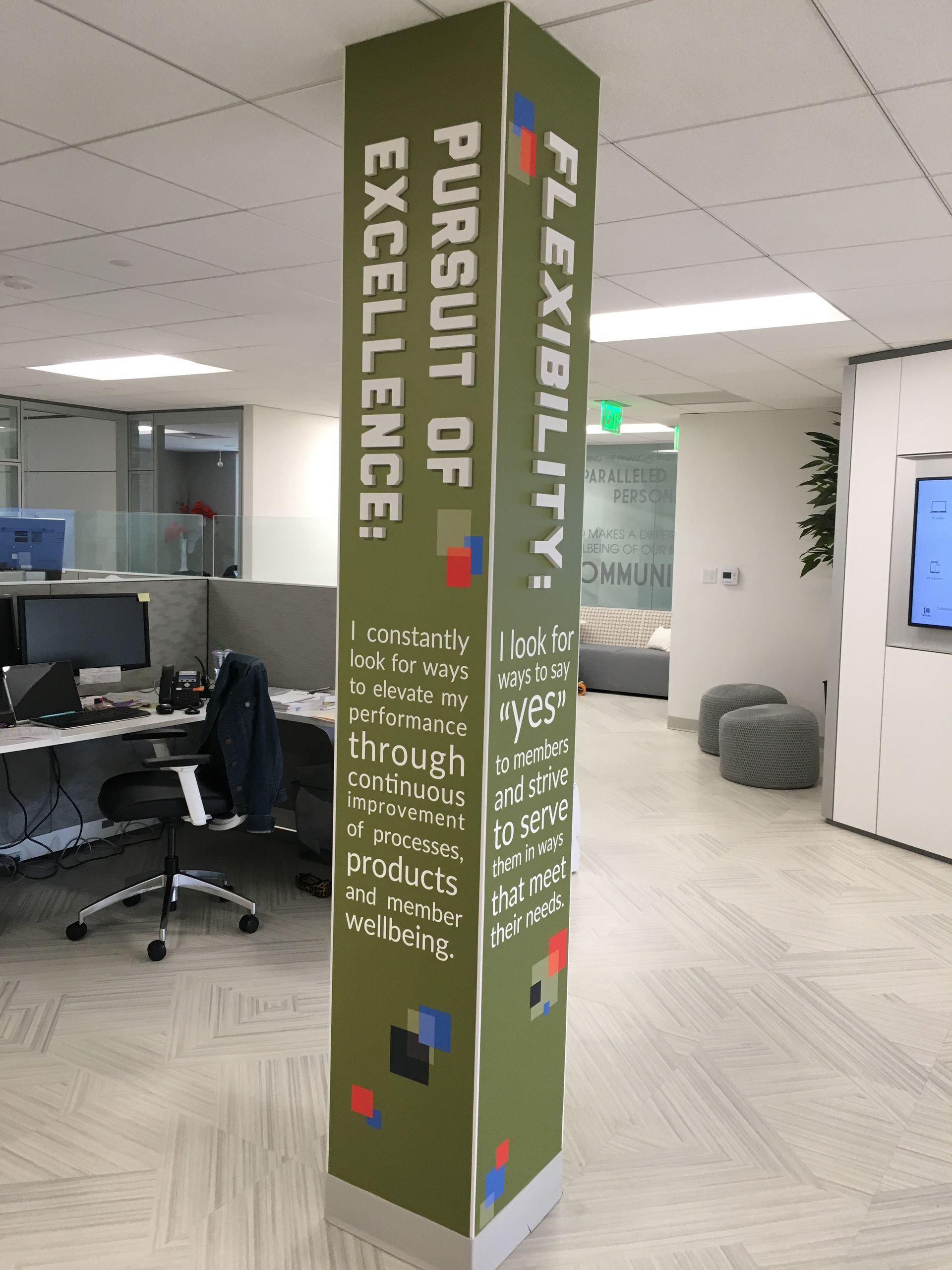 A pillar in an office with the words pursuit of excellence and flexibility on it