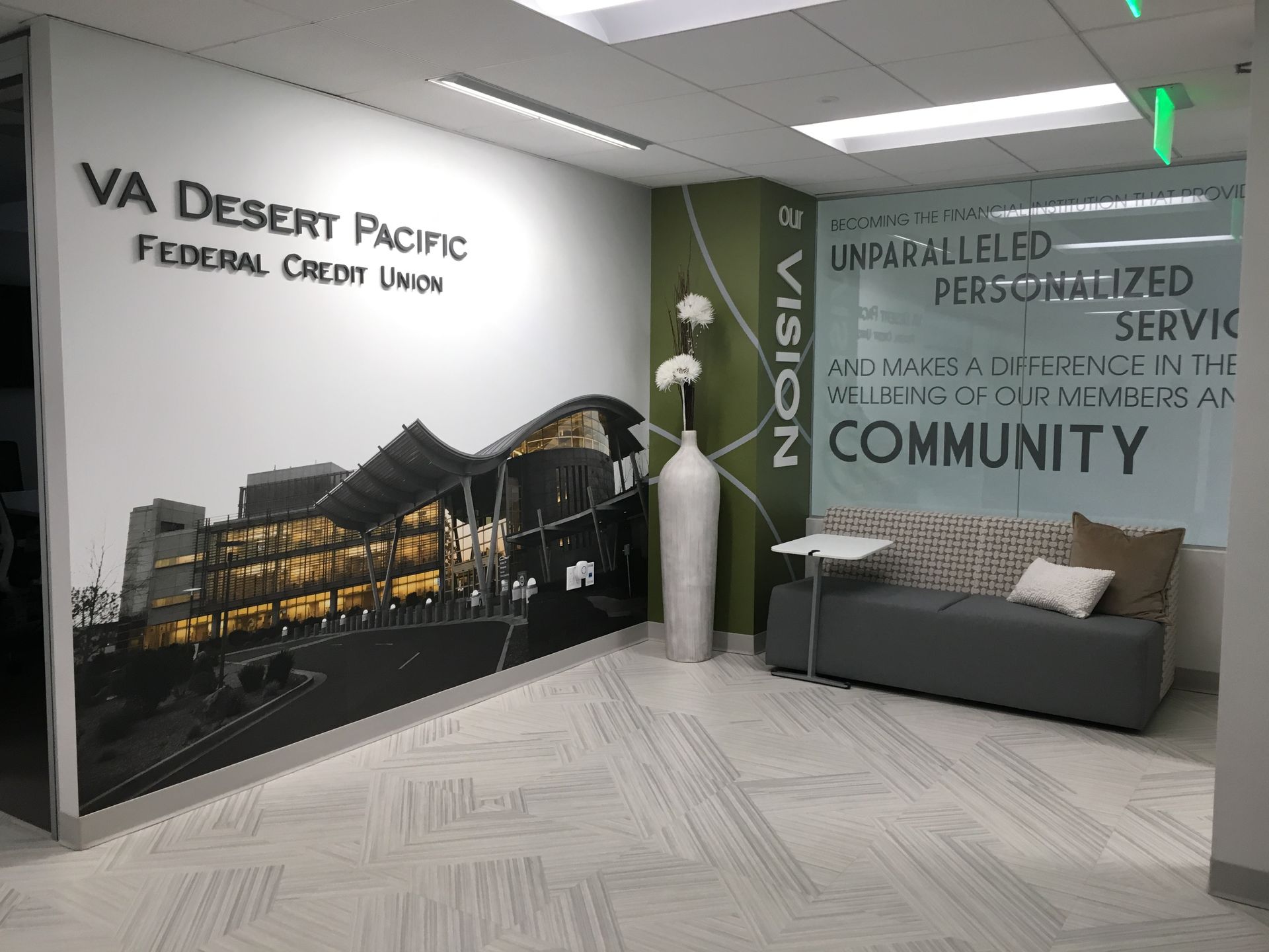 A lobby with a couch and a mural on the wall.