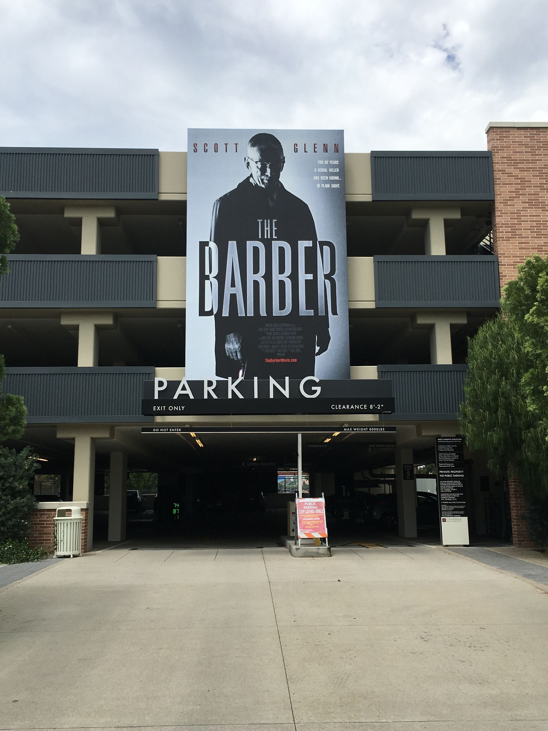 A parking garage with a large sign that says barber