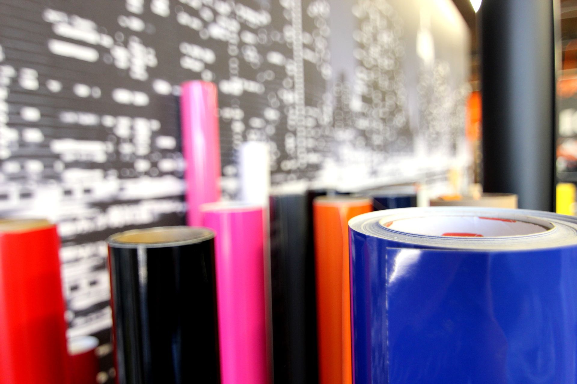 A bunch of different colored rolls of vinyl sitting next to each other.