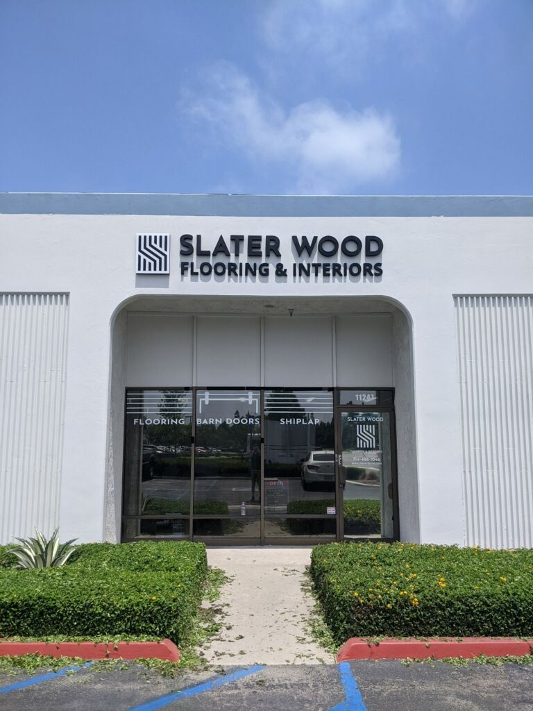 A white building with a sign that says slater wood flooring & interiors