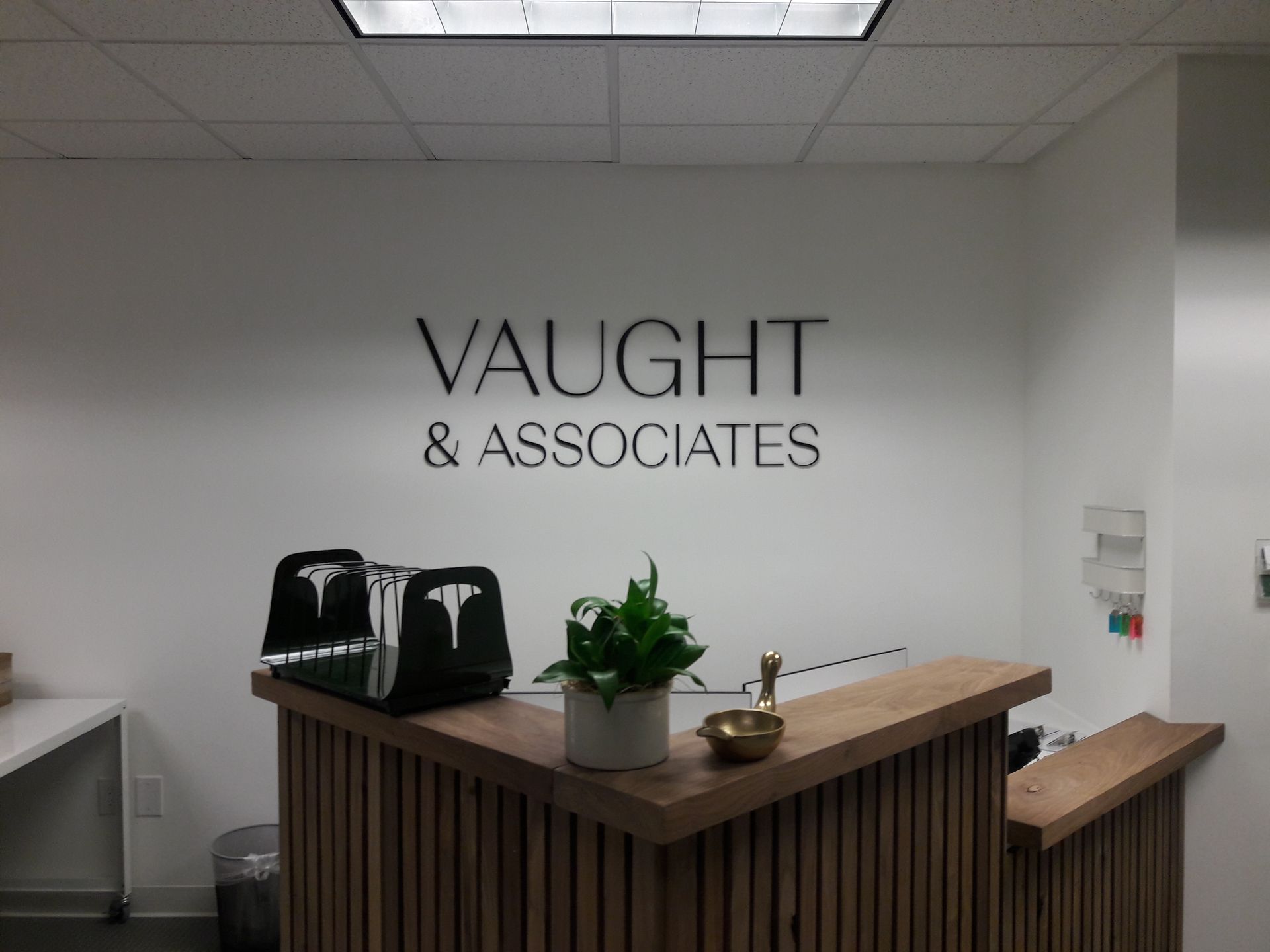 A reception desk for vaught & associates with a plant on it