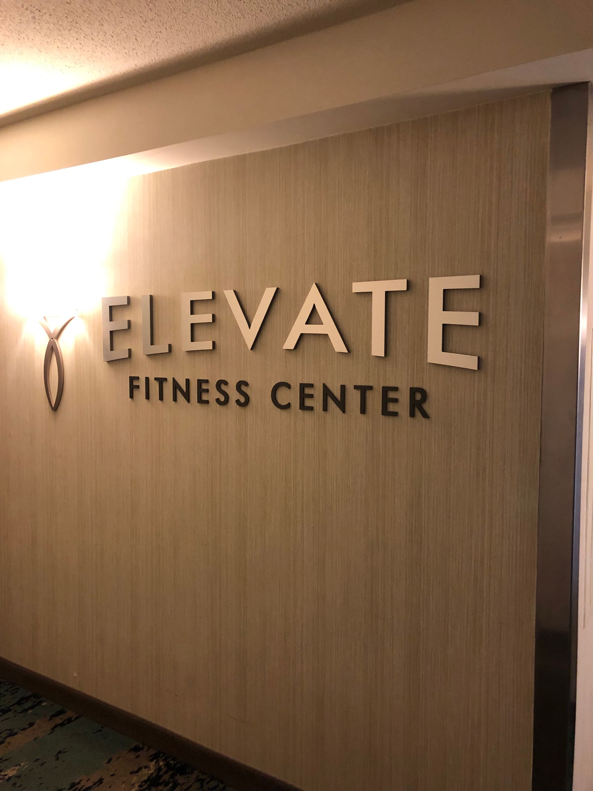 A sign on a wall that says elevate fitness center