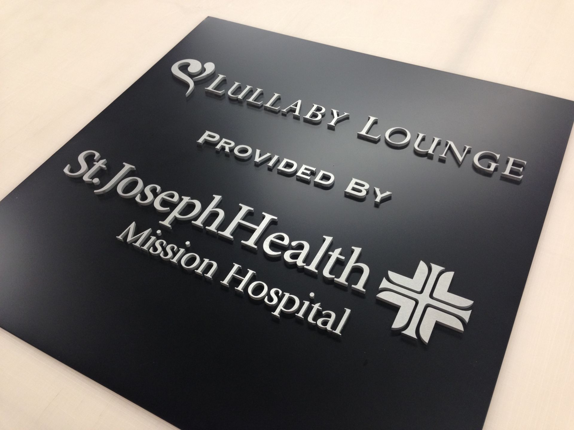 A black sign that says lullaby lounge provided by st. joseph health mission hospital