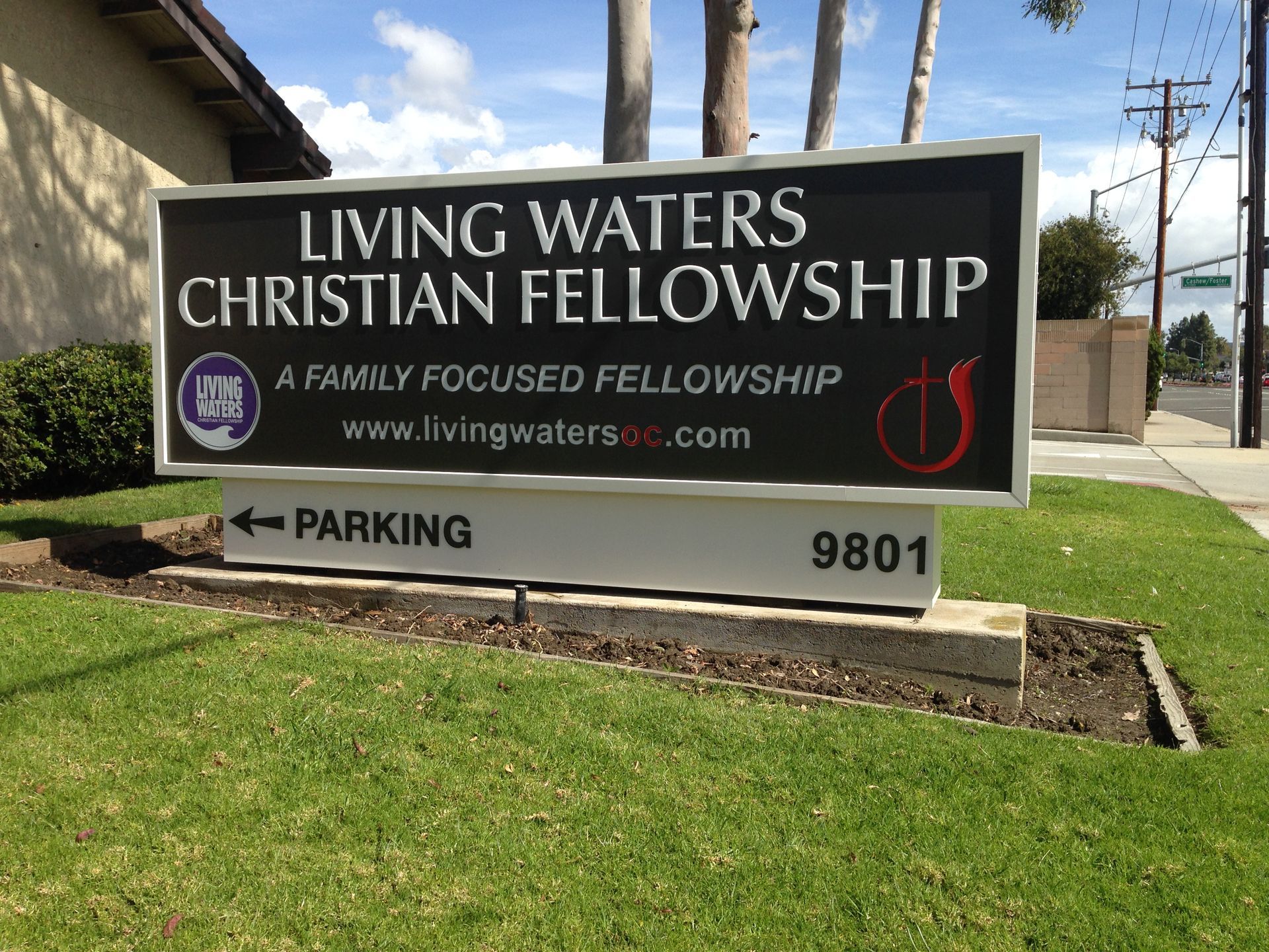 A sign for living waters christian fellowship is in the grass