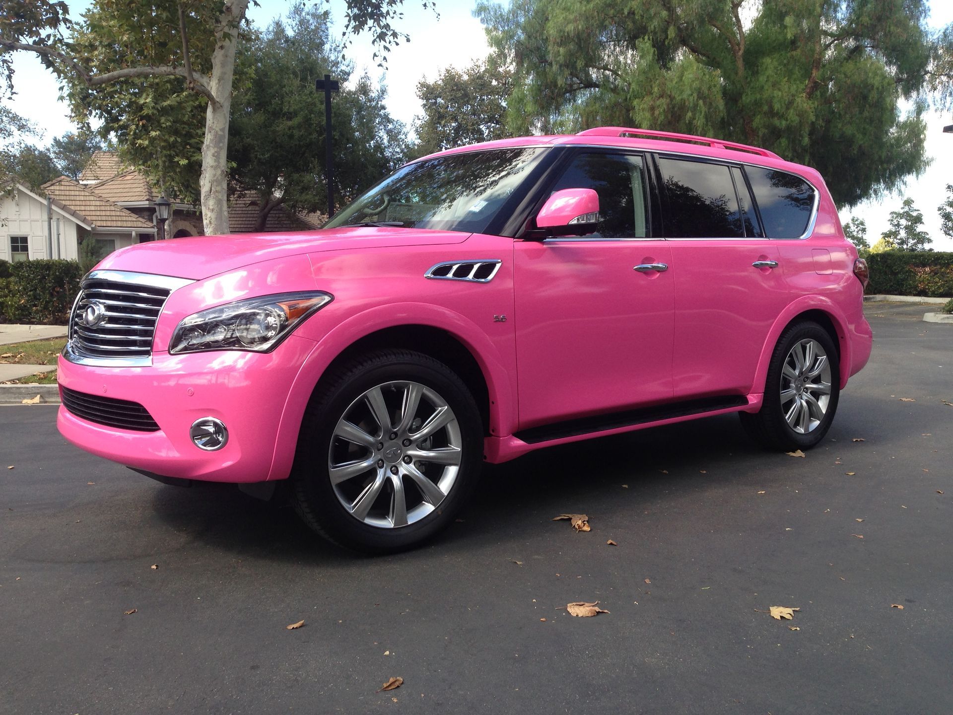 A pink suv is parked on the side of the road