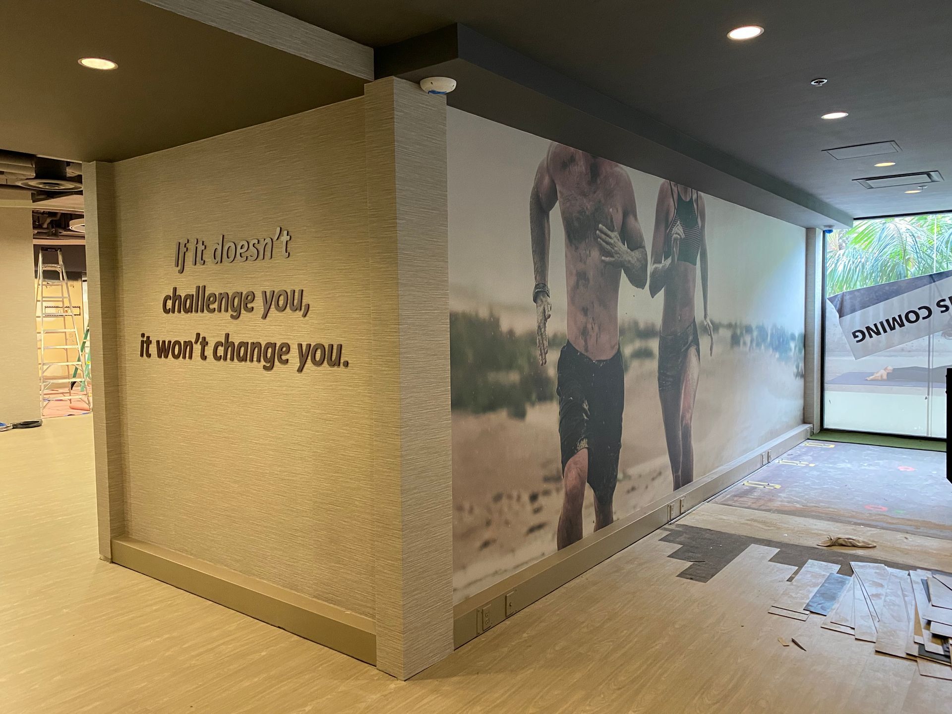 A wall with a picture of two people running on it and a quote on it.