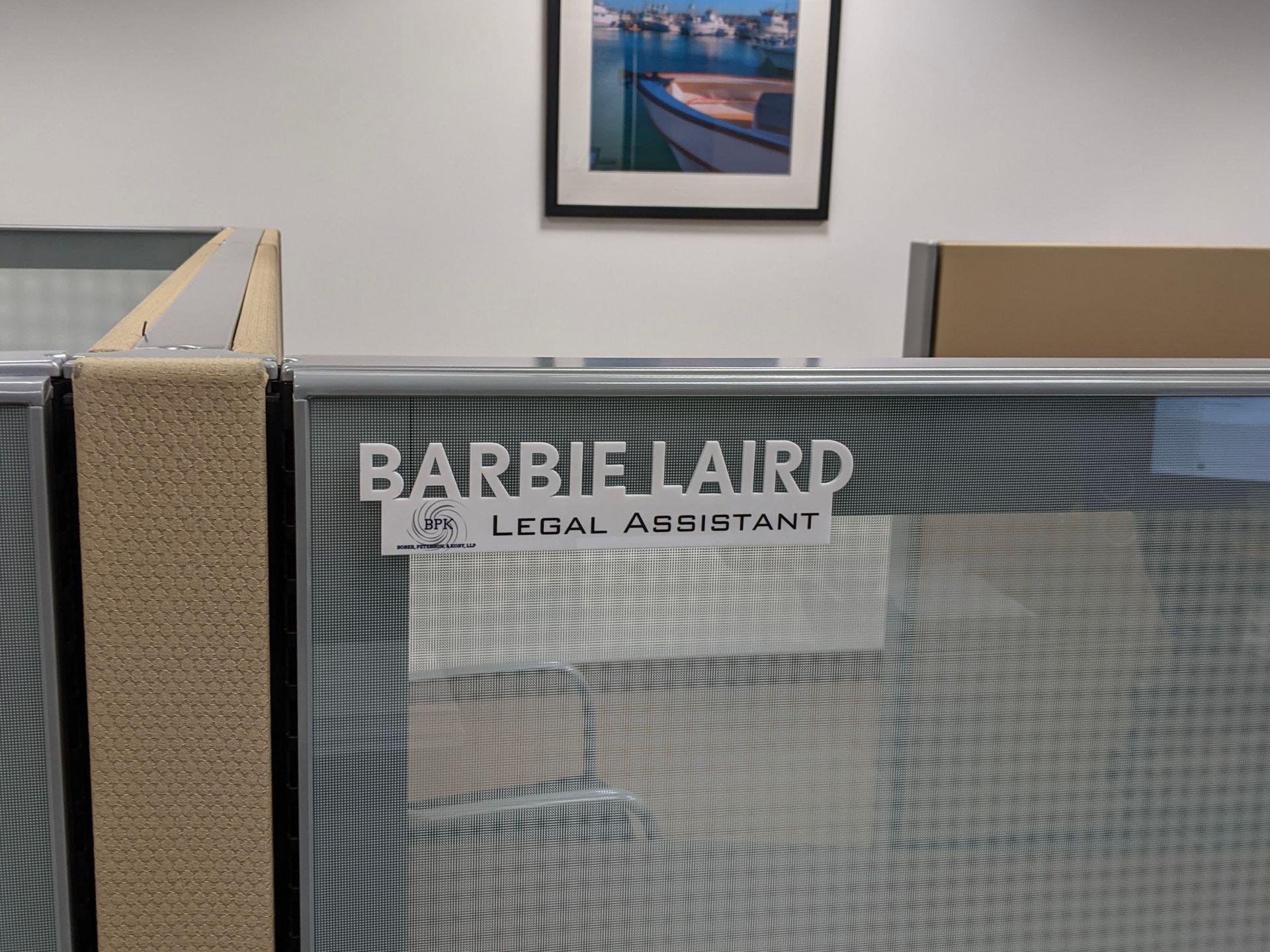A cubicle with a sign that says barbie laird