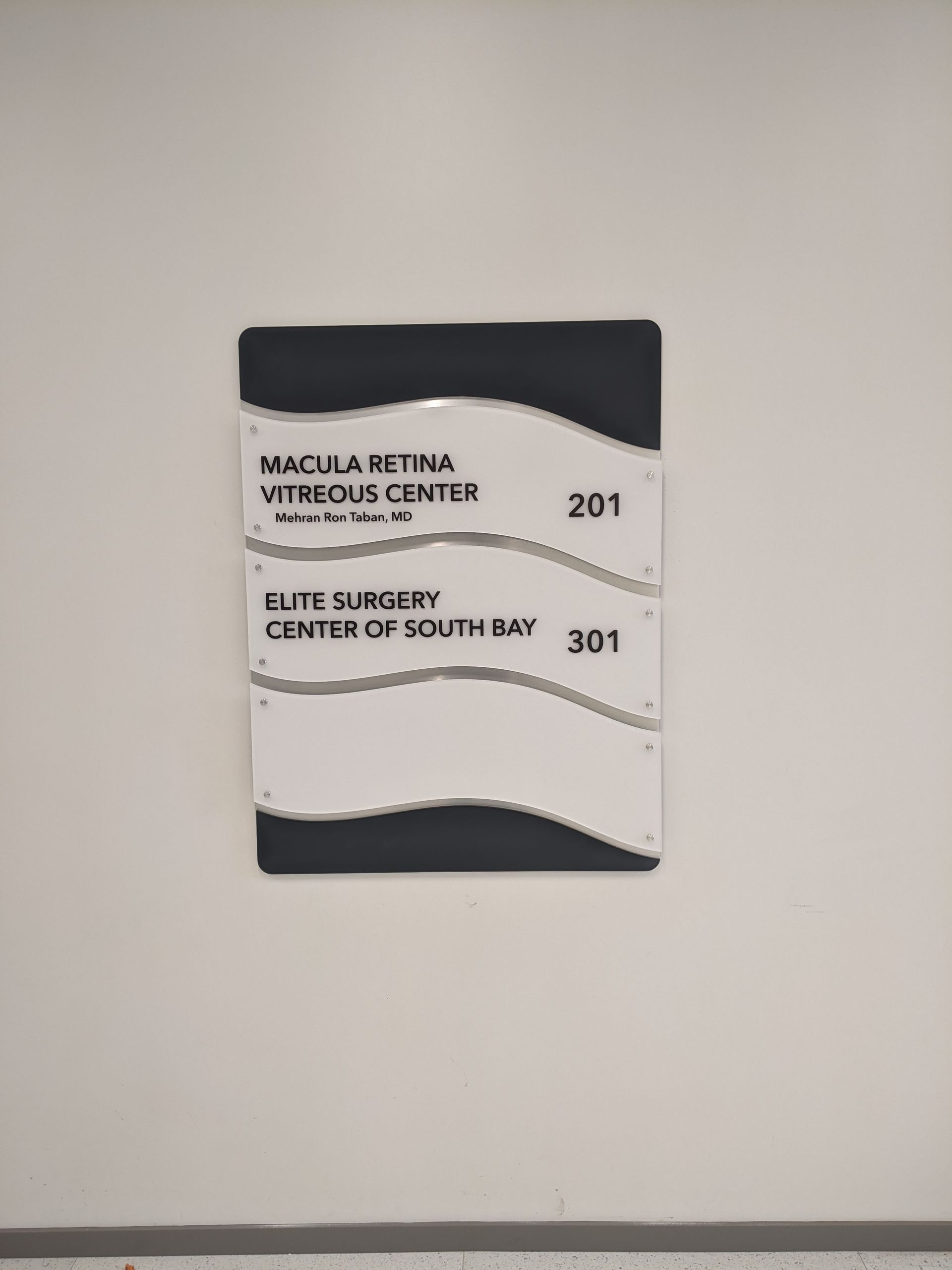 A sign on a wall that says elite surgery center of south bay