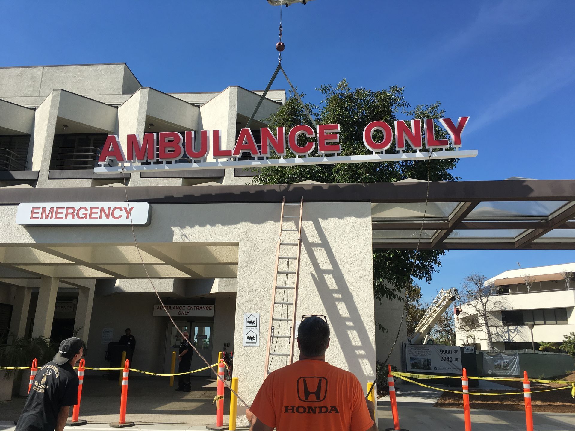 A man is standing in front of an ambulance only sign