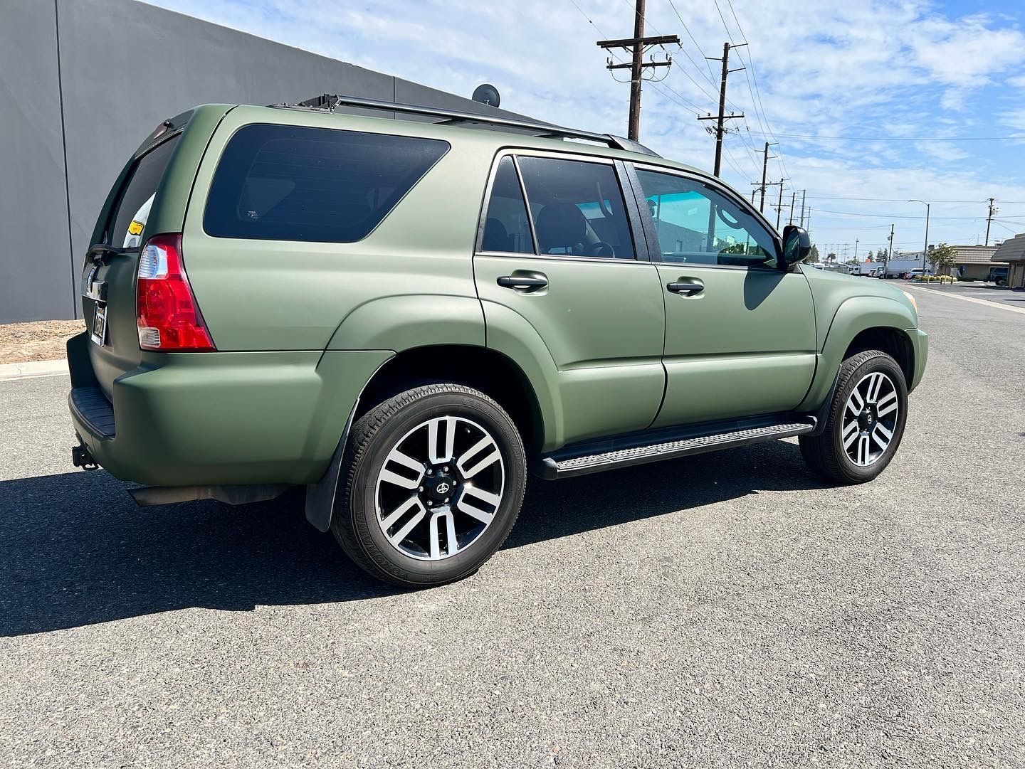 A green suv is parked on the side of the road.