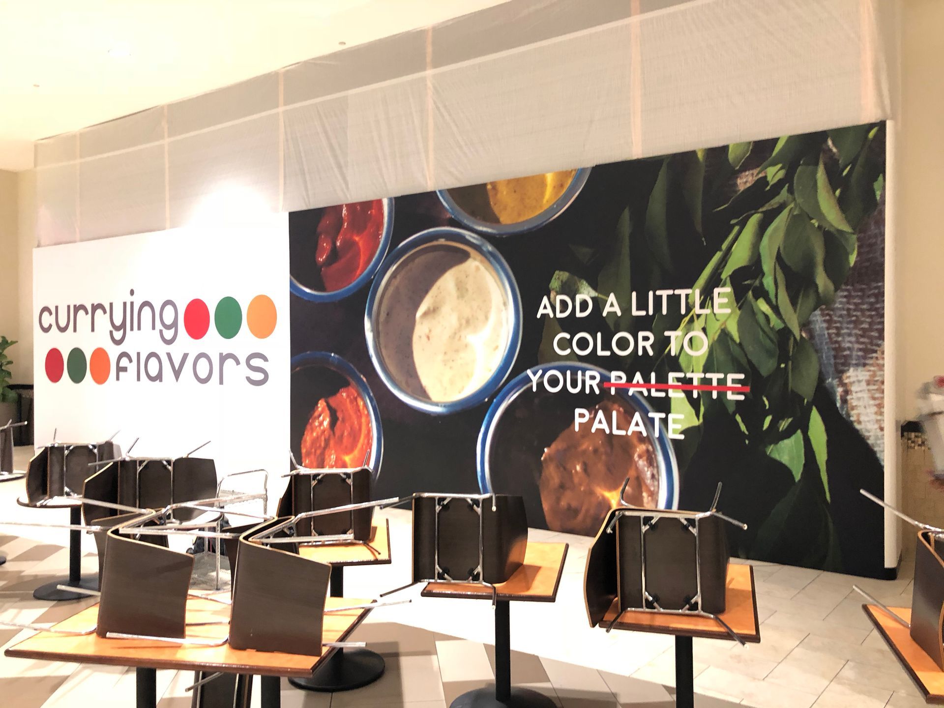 A restaurant with tables and chairs and a sign that says `` add a little color to your palette palate ''