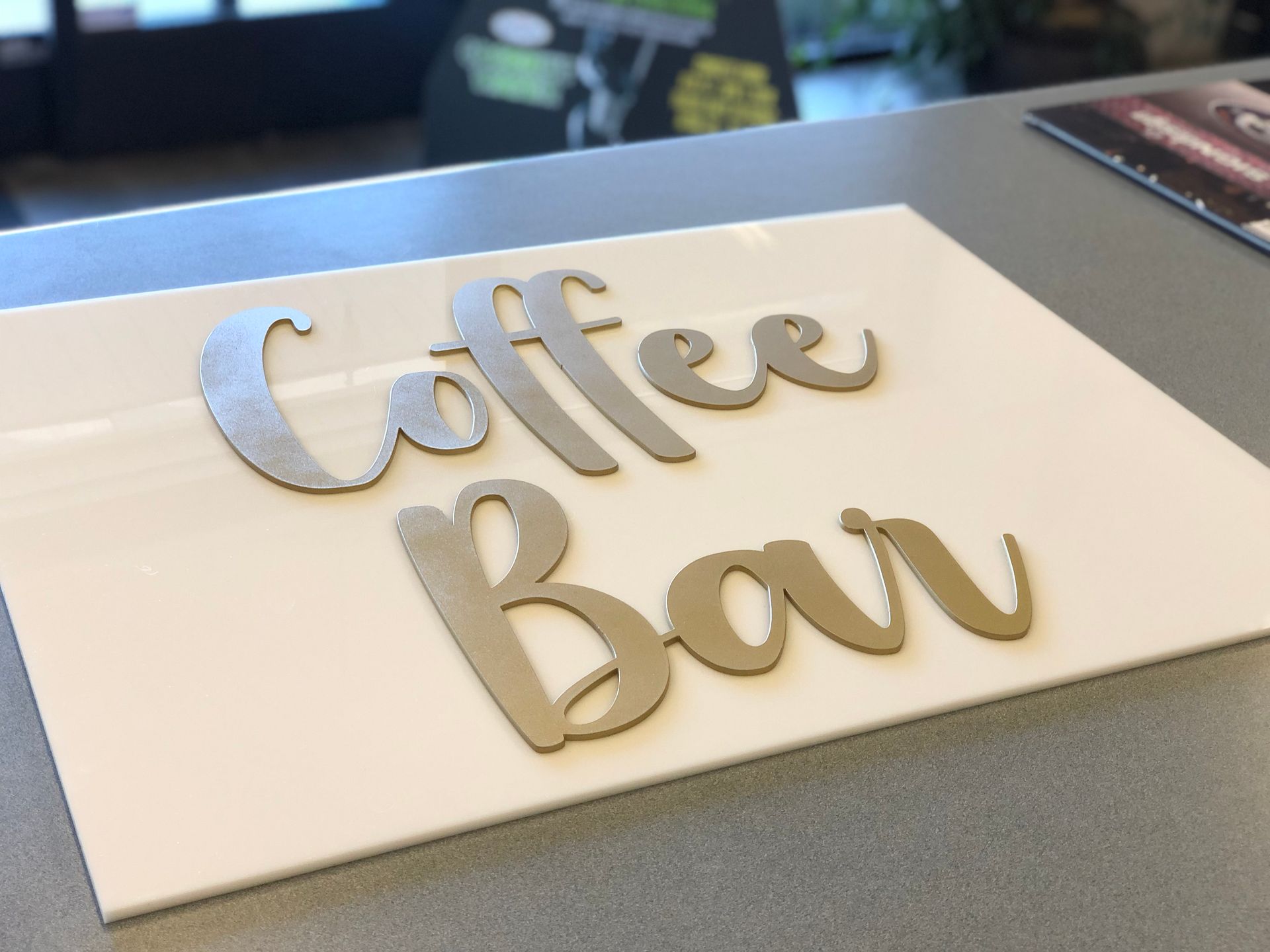 A white sign that says coffee bar on it