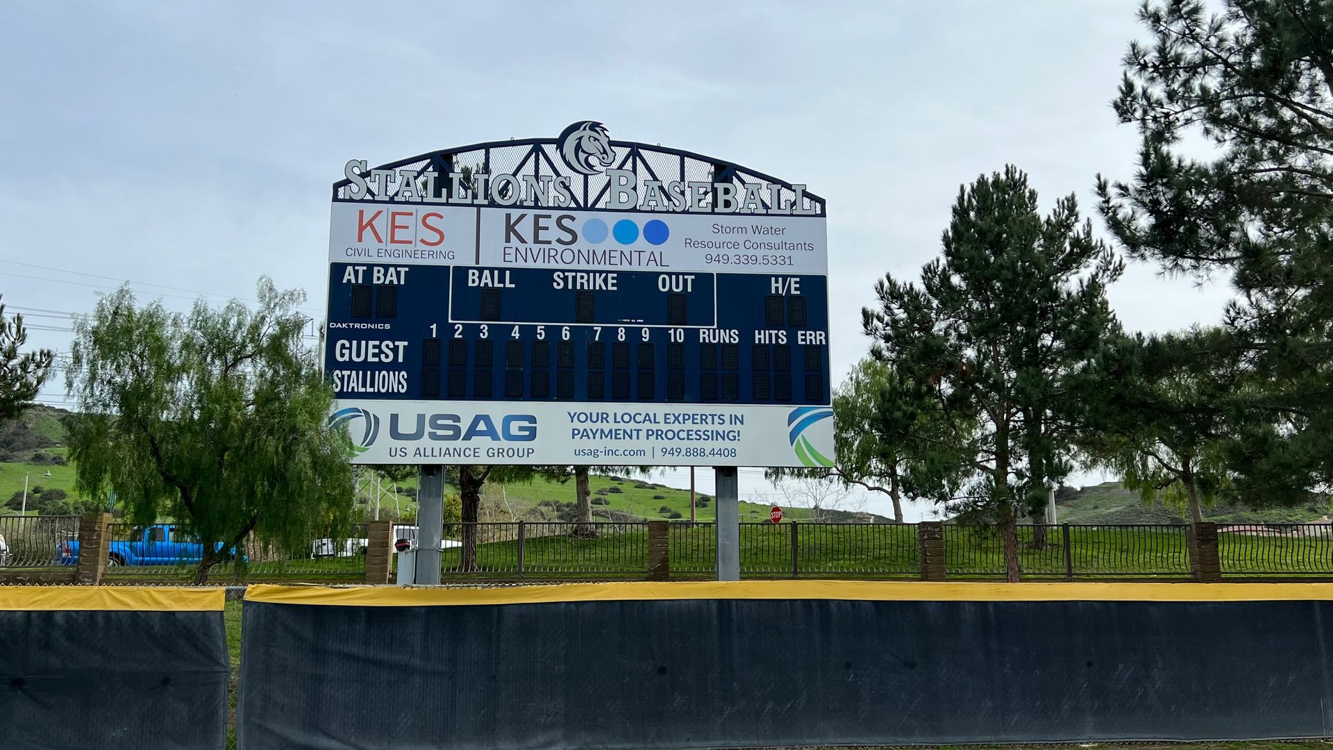 A large scoreboard is sitting on top of a baseball field.
