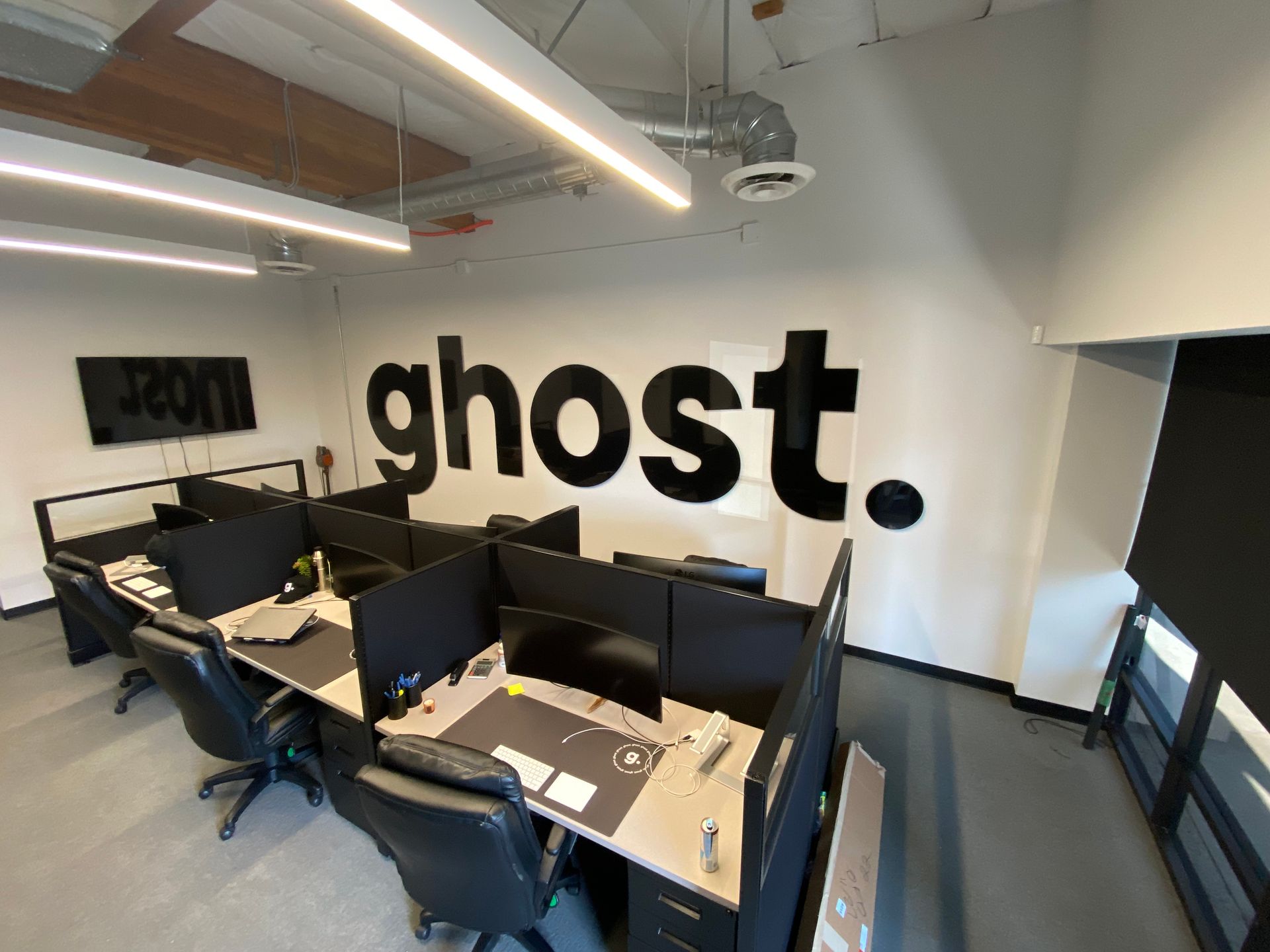A room with cubicles and a sign that says ghost on the wall.
