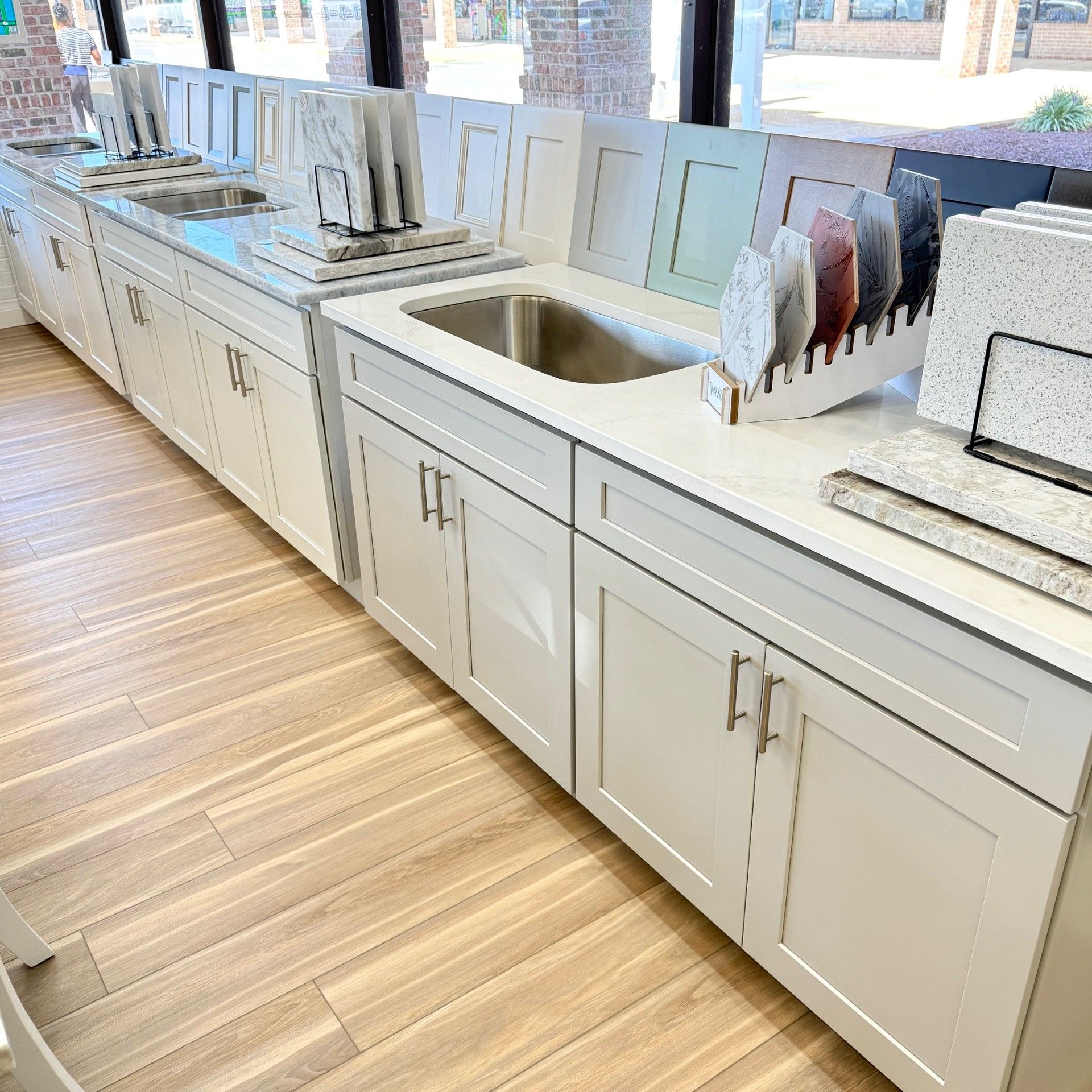 White kitchen cabinets with countertops, showcasing sample materials.