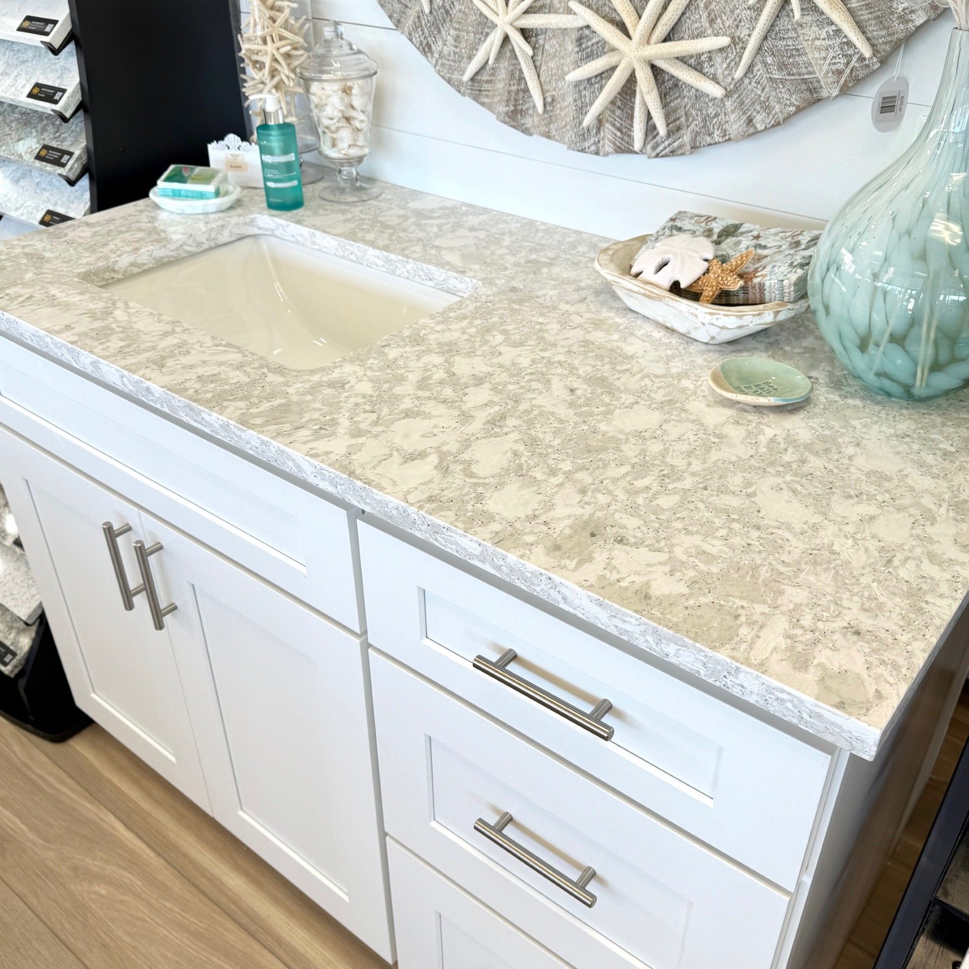 White bathroom vanity with light gray countertop, sink, and decorative starfish.