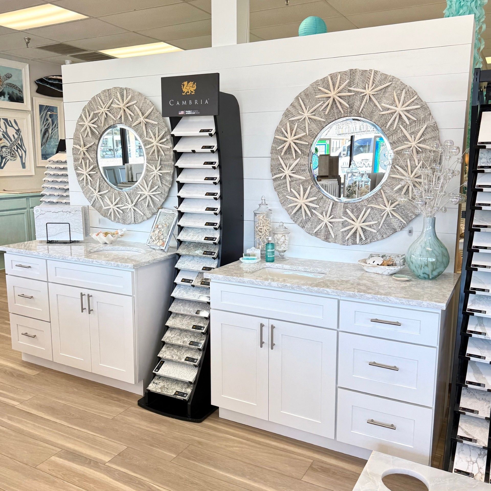 White bathroom vanities with starfish mirrors and stone samples on display.