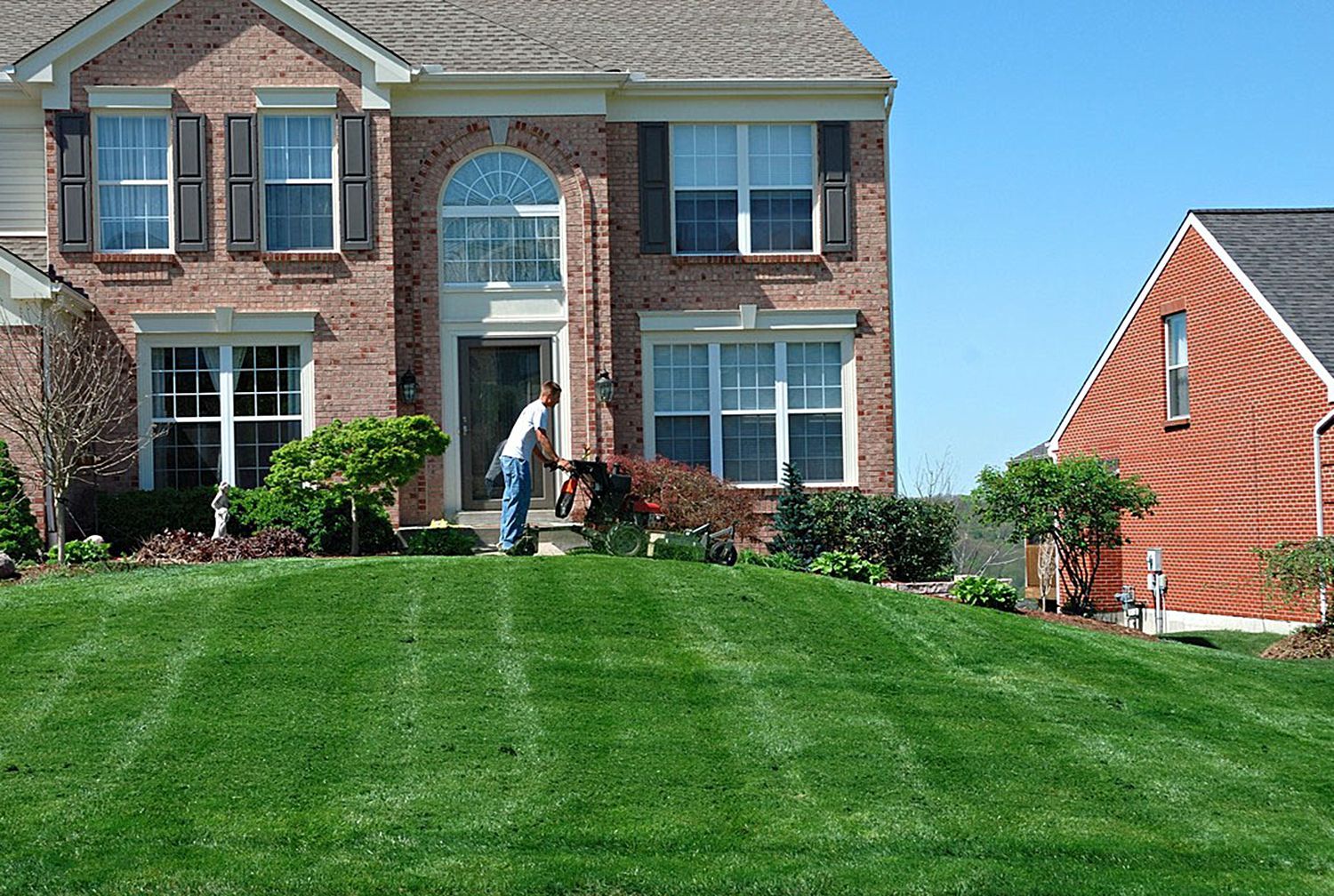 a man mowing the lush green lawn