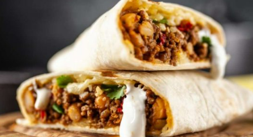 Two stacked burritos filled with seasoned ground meat, beans, and melted cheese, drizzled with sour cream.